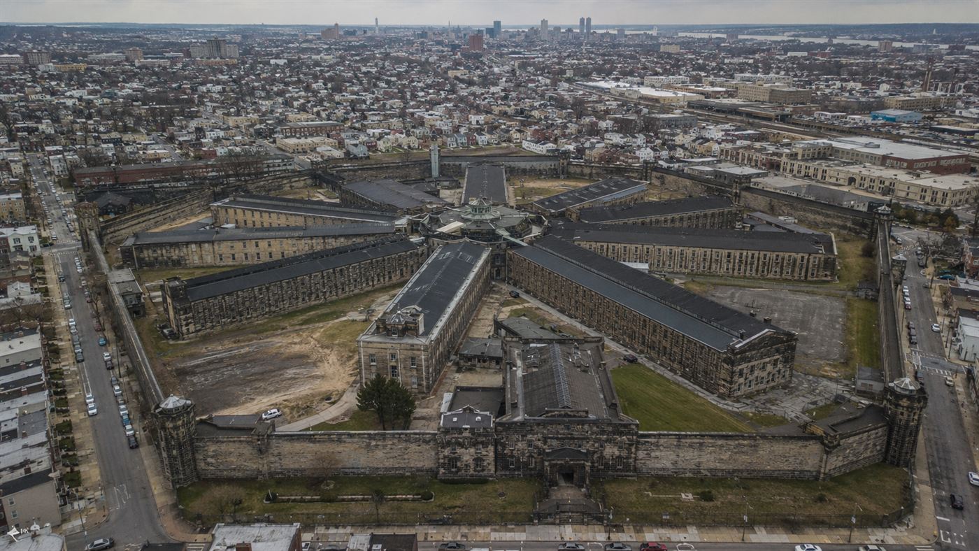 Aerial view of the fortress-like Eastern State Penitentiary showing its long cell blocks radiating like spokes from a central hub