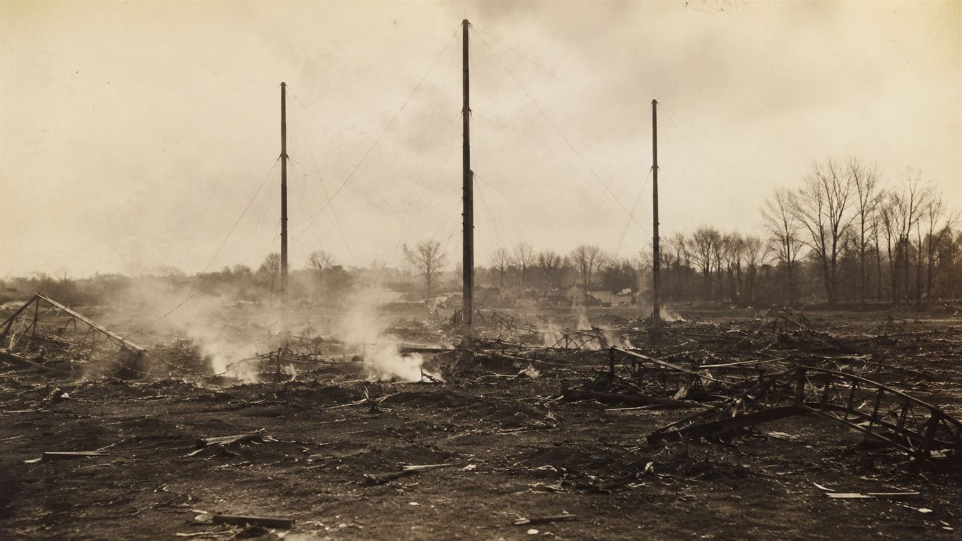 The charred aftermath of the Hartford circus fire, bare tent poles standing over blackened ground and twisted bleacher frames