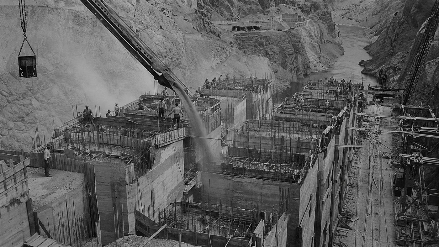 The Hoover Dam under construction as interlocking concrete blocks threaded with cooling pipes