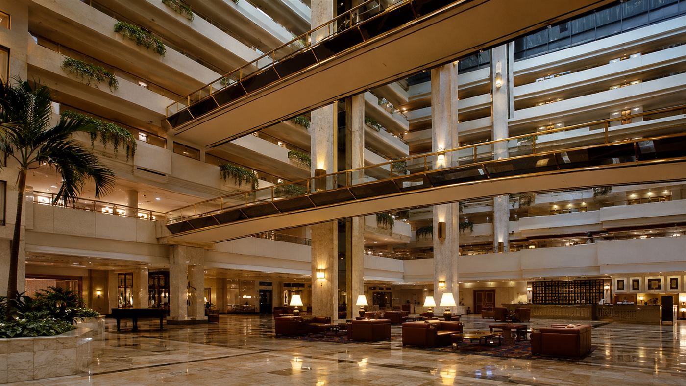 The grand atrium of the Hyatt Regency, where the walkway collapse happened, with suspended skywalks crossing high above the lobby floor
