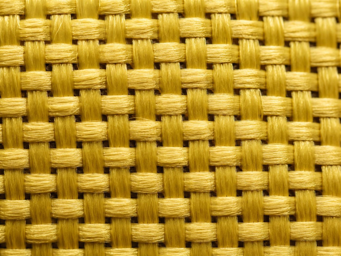Close-up of woven golden Kevlar aramid fabric, the fibre Stephanie Kwolek discovered