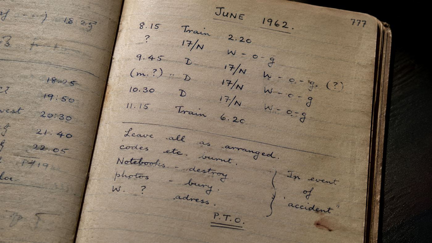 An open 1960s notebook page with cryptic handwritten notes and times in faded ink