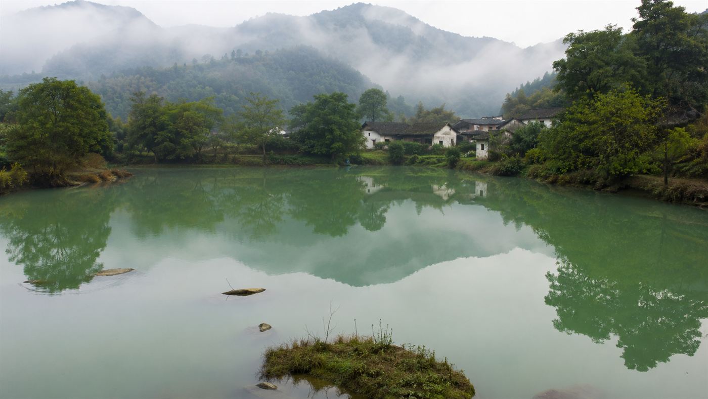 A still green village pond in rural China, the kind that hid the Longyou Caves below the surface