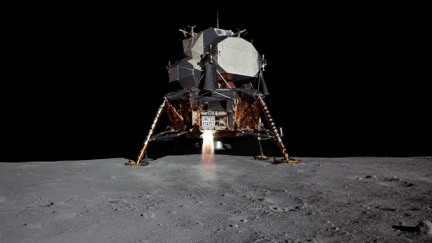 The Apollo lunar module descending toward the grey cratered surface of the Moon in 1969