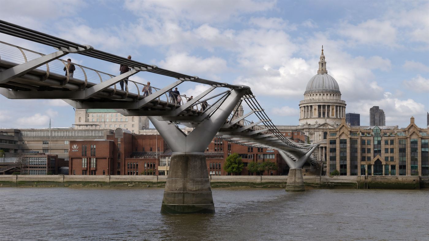 The London Millennium Bridge, a slender steel footbridge over the Thames with St Paul's Cathedral behind