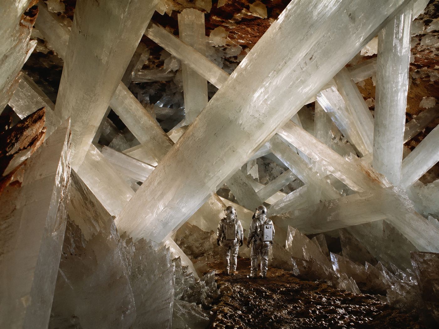 Explorers in ice-cooled protective suits and breathing masks among the giant crystals of the Naica crystal cave