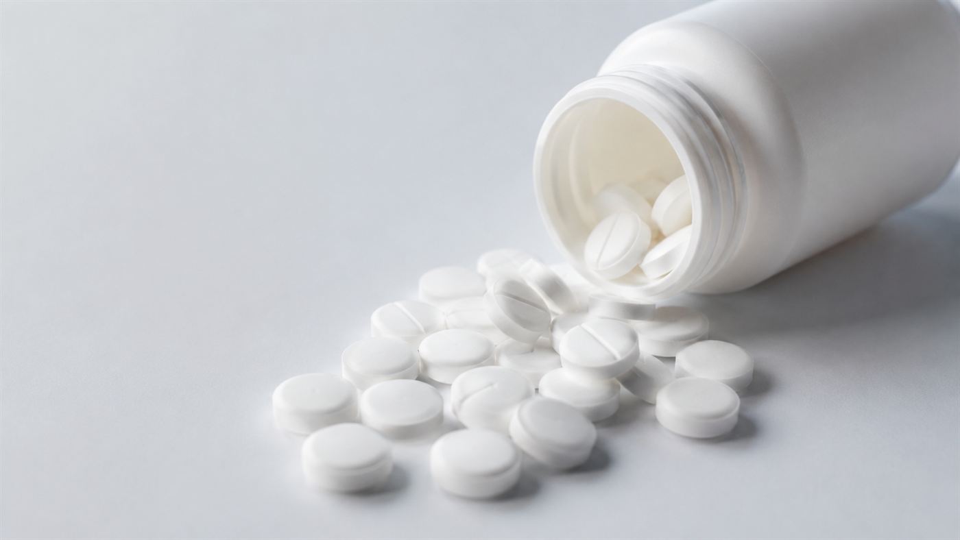 Plain white pills spilling from a small unlabeled bottle, representing the placebo effect