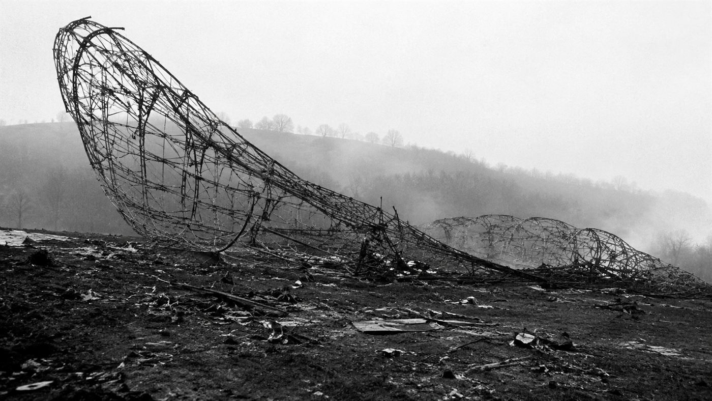 The blackened twisted metal framework of the R101 airship wreckage on a French hillside after the 1930 fire
