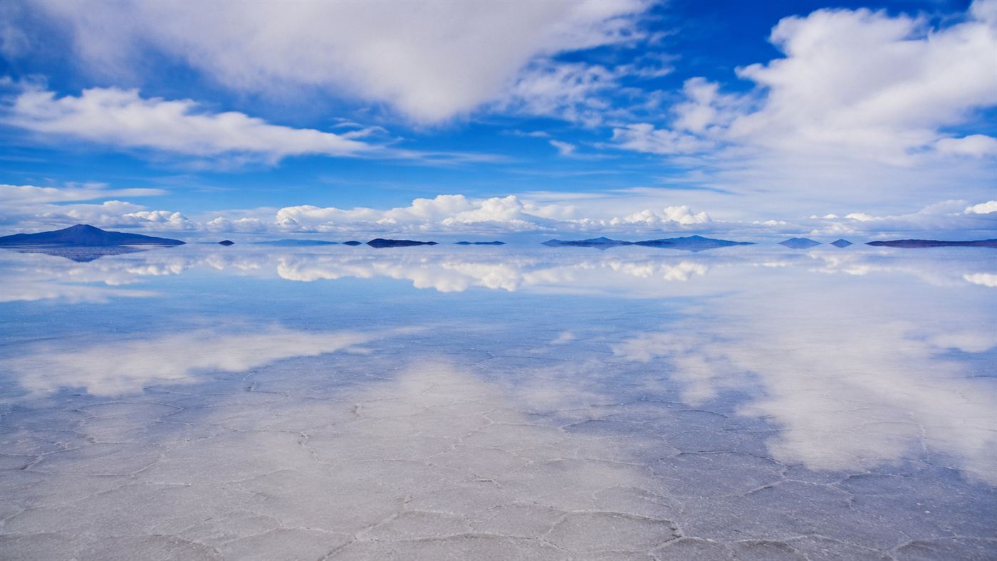 The Salar de Uyuni salt flat in Bolivia turned into a vast mirror reflecting the sky and clouds