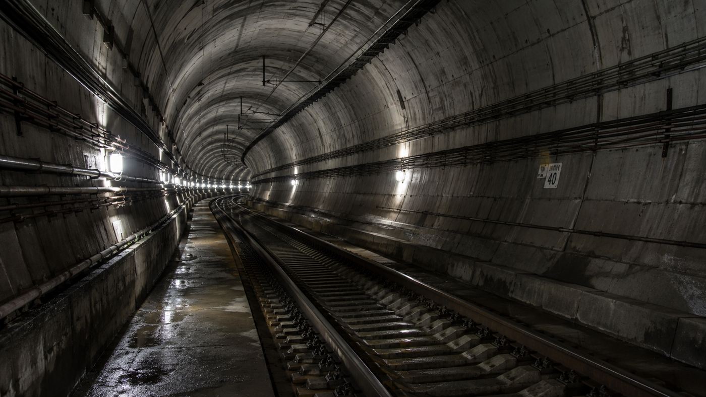 The long interior of the Seikan Tunnel curving into the distance deep underground with a single rail track