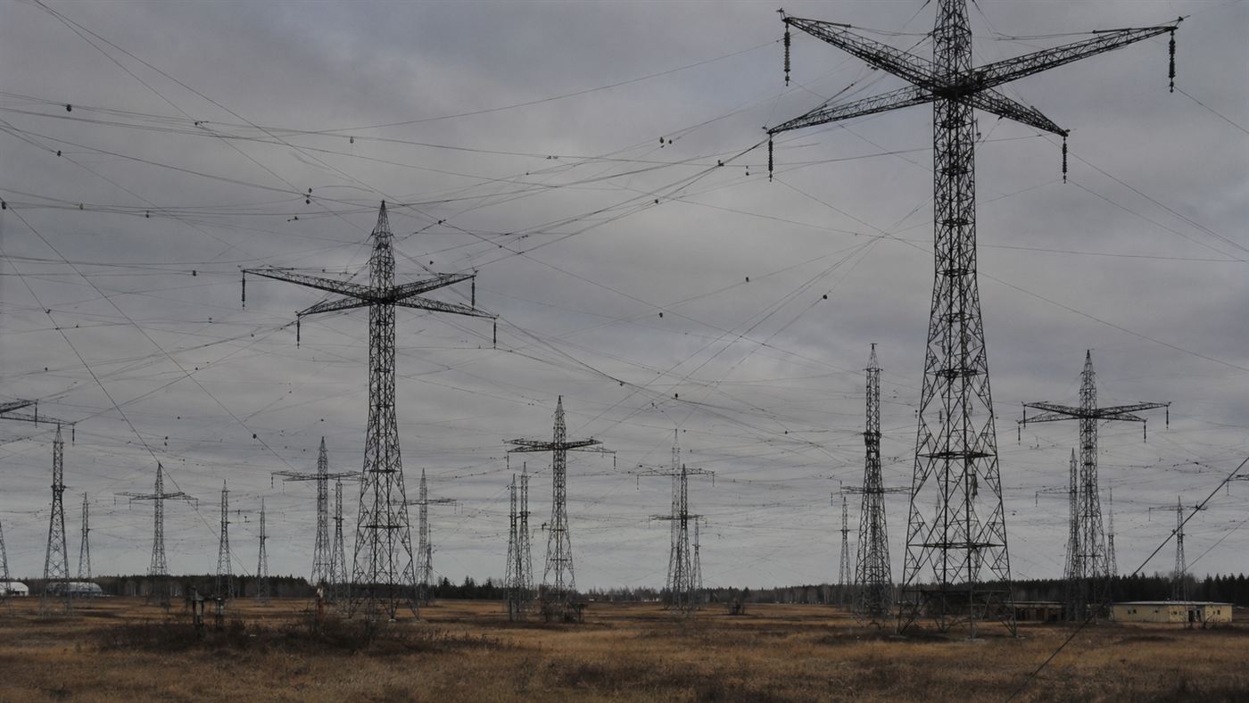 A large array of tall shortwave radio transmitter antenna towers in an open field