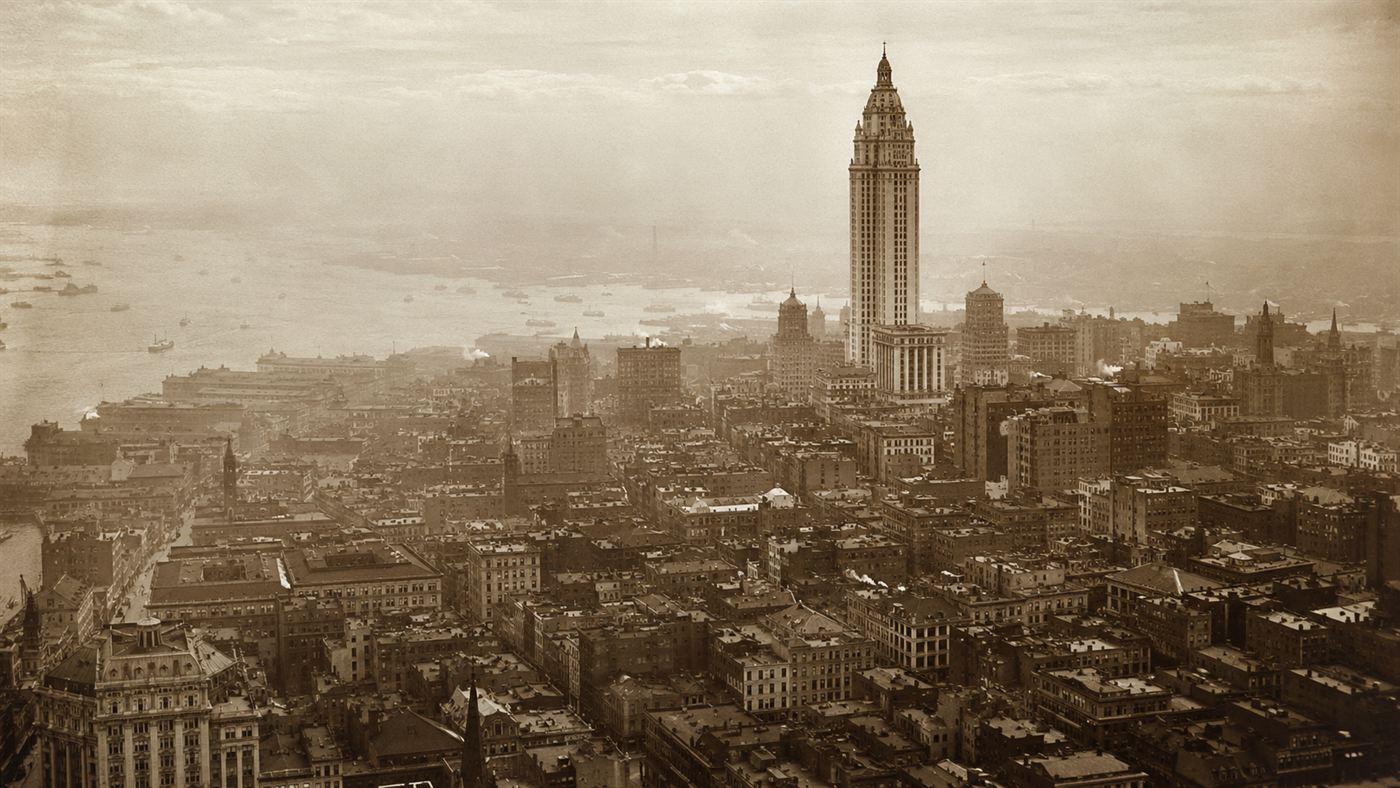 The Singer Building's crowned tower standing tall above the dense low rooftops of early 1900s Lower Manhattan