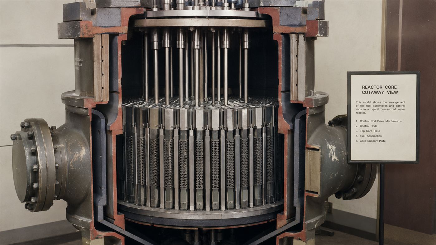 A cutaway view of a nuclear reactor control rod mechanism above a reactor core, central to the SL-1 accident