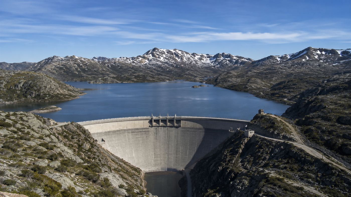 A large concrete hydro-electric dam of the Snowy Mountains Scheme set in rugged Australian alpine mountains