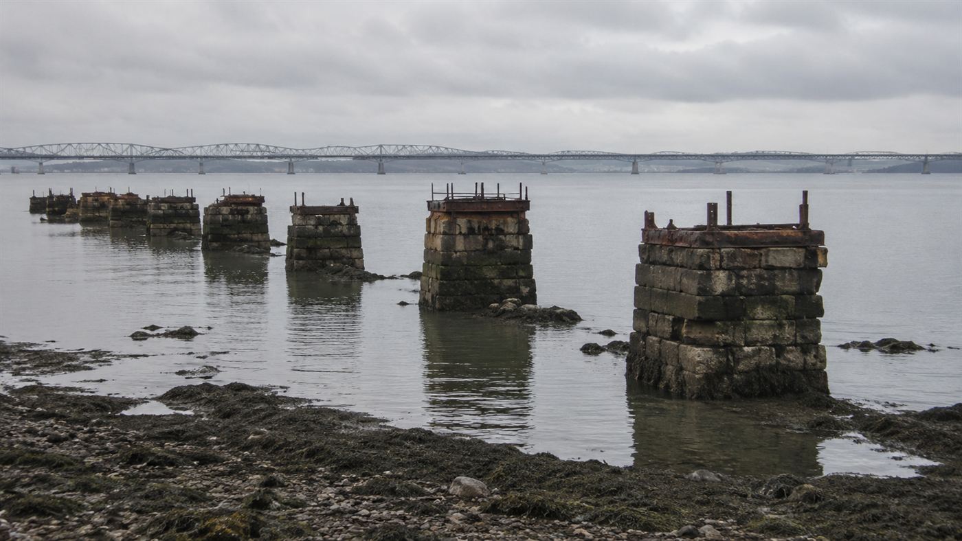 The stumps of the old first Tay Bridge piers standing in the water beside the later bridge
