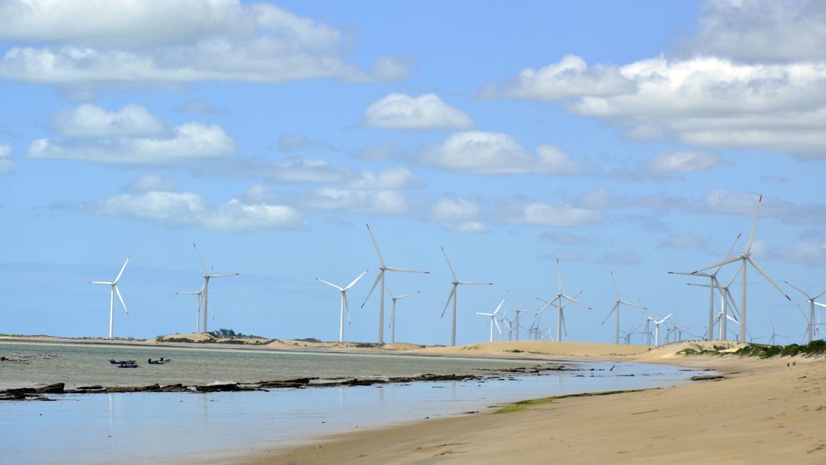 Aerogeradores enfileirados atrás das dunas na praia de Enxu Queimado, em Pedra Grande, no Rio Grande do Norte