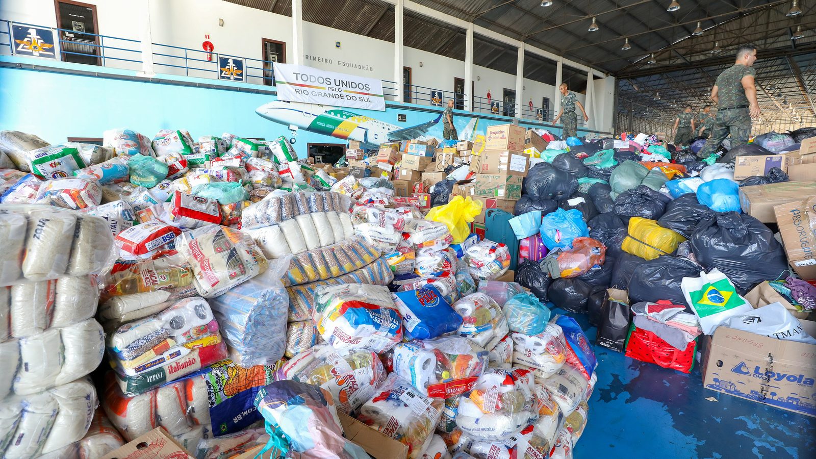 Doações de alimentos empilhadas em hangar de Brasília para vítimas da água da enchente no Rio Grande do Sul, em maio de 2024