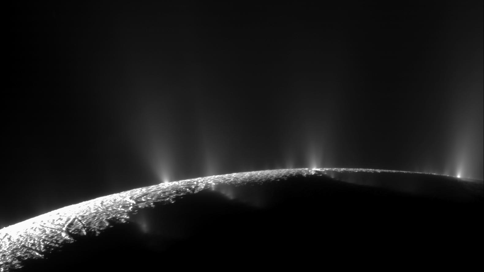 Encélado: jatos de gelo e vapor saindo das rachaduras do polo sul da lua de Saturno, fotografados contra o fundo preto do espaço pela sonda Cassini