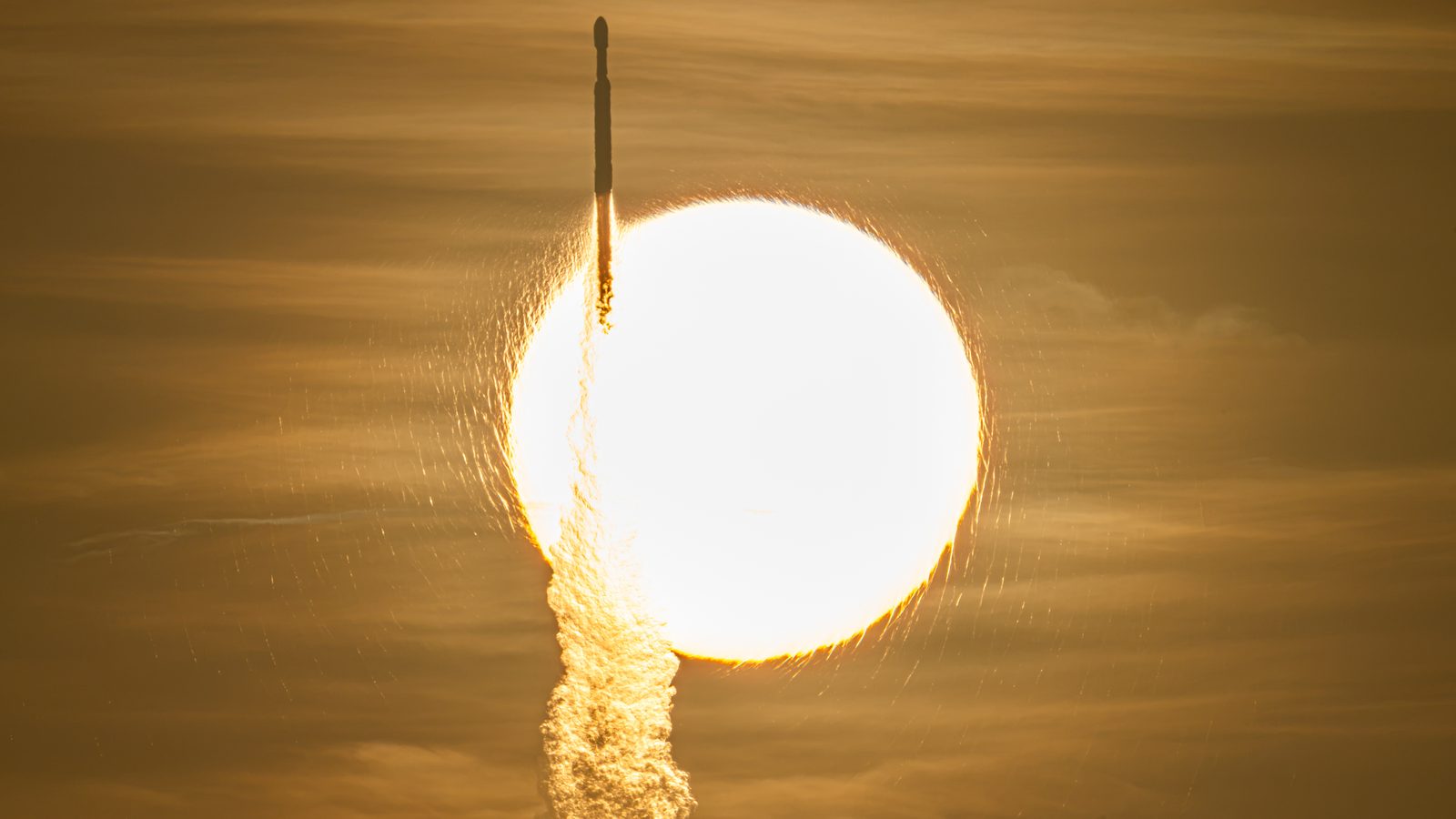 Foguete Falcon Heavy sobe diante do Sol levando o telescópio Roman da NASA, em 30 de agosto de 2026