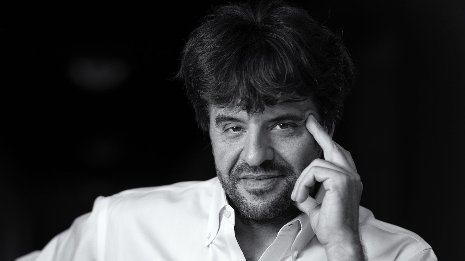 Karl Deisseroth sentado numa cadeira de madeira, em retrato em preto e branco, um dos três vencedores do Nobel de Medicina 2026