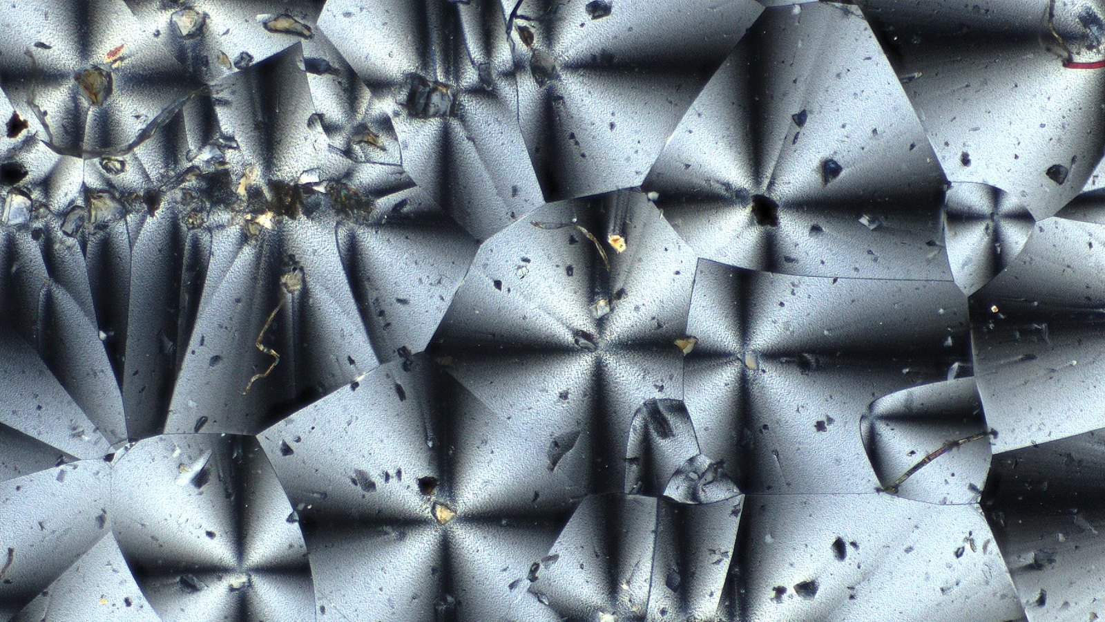 Poeira da Lua: vista no microscópio do material da NASA feito com plástico e poeira lunar simulada, com cristais cinza e prateados em forma de estrela