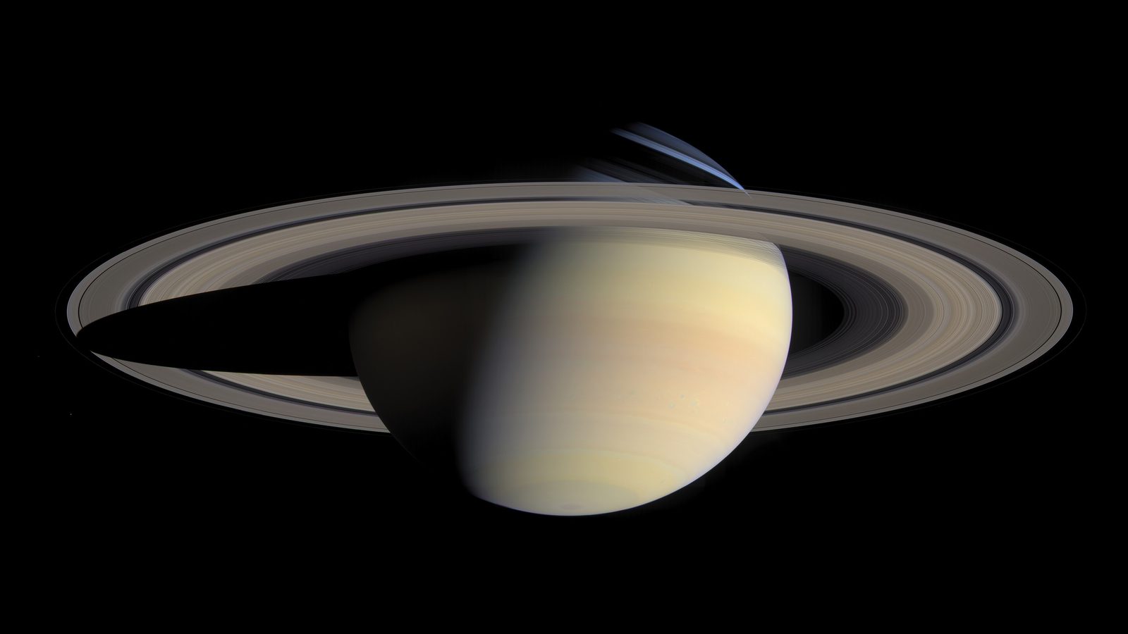 Saturno com os anéis largos e a sombra do planeta sobre eles, em fundo preto: os anéis de Saturno vistos pela sonda Cassini