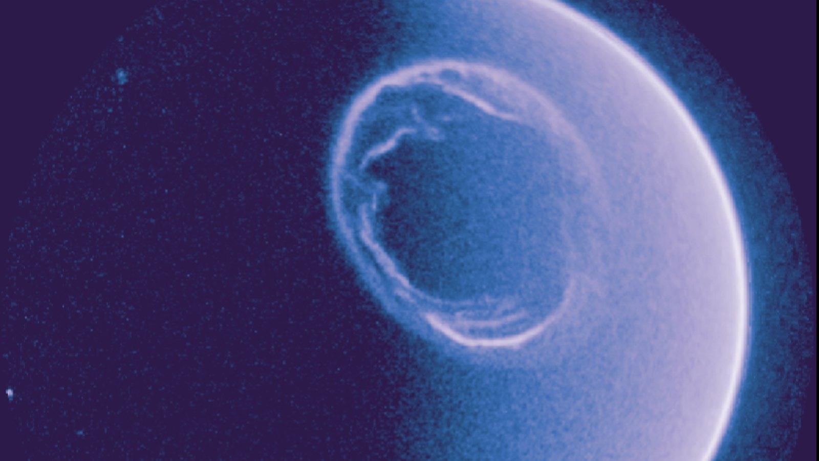 Anel da aurora boreal em volta do Polo Norte visto em luz ultravioleta pela câmera do satélite Smile, em tons de azul e lilás, com a borda da Terra iluminada à direita