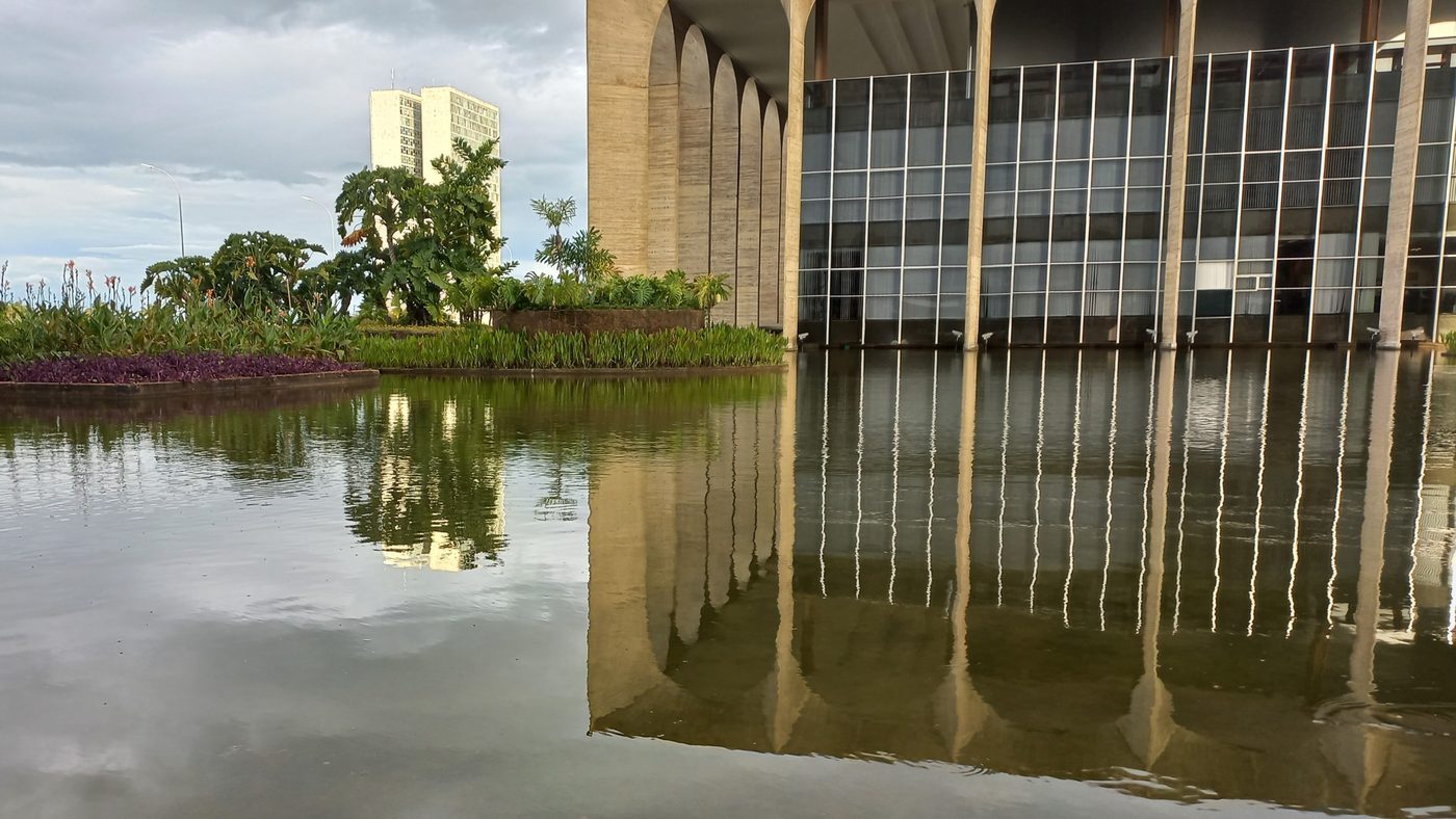 Espelho d'água onde vivem as tartarugas do Itamaraty, com os arcos do palácio refletidos e canteiros de plantas, em Brasília