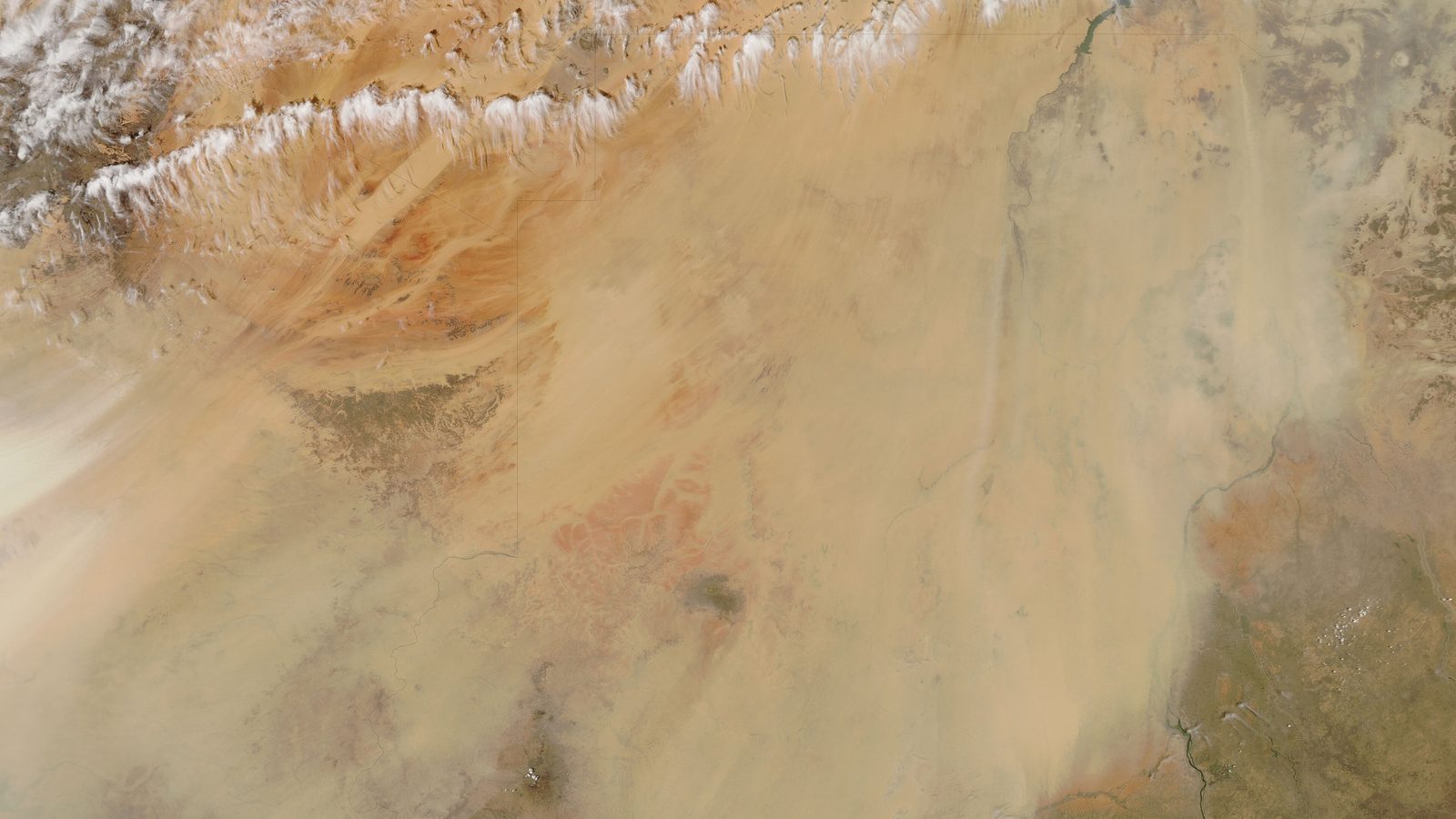 Imagem de satélite de uma tempestade de poeira cor de areia cobrindo o deserto do Saara, com faixas de nuvens brancas ao norte