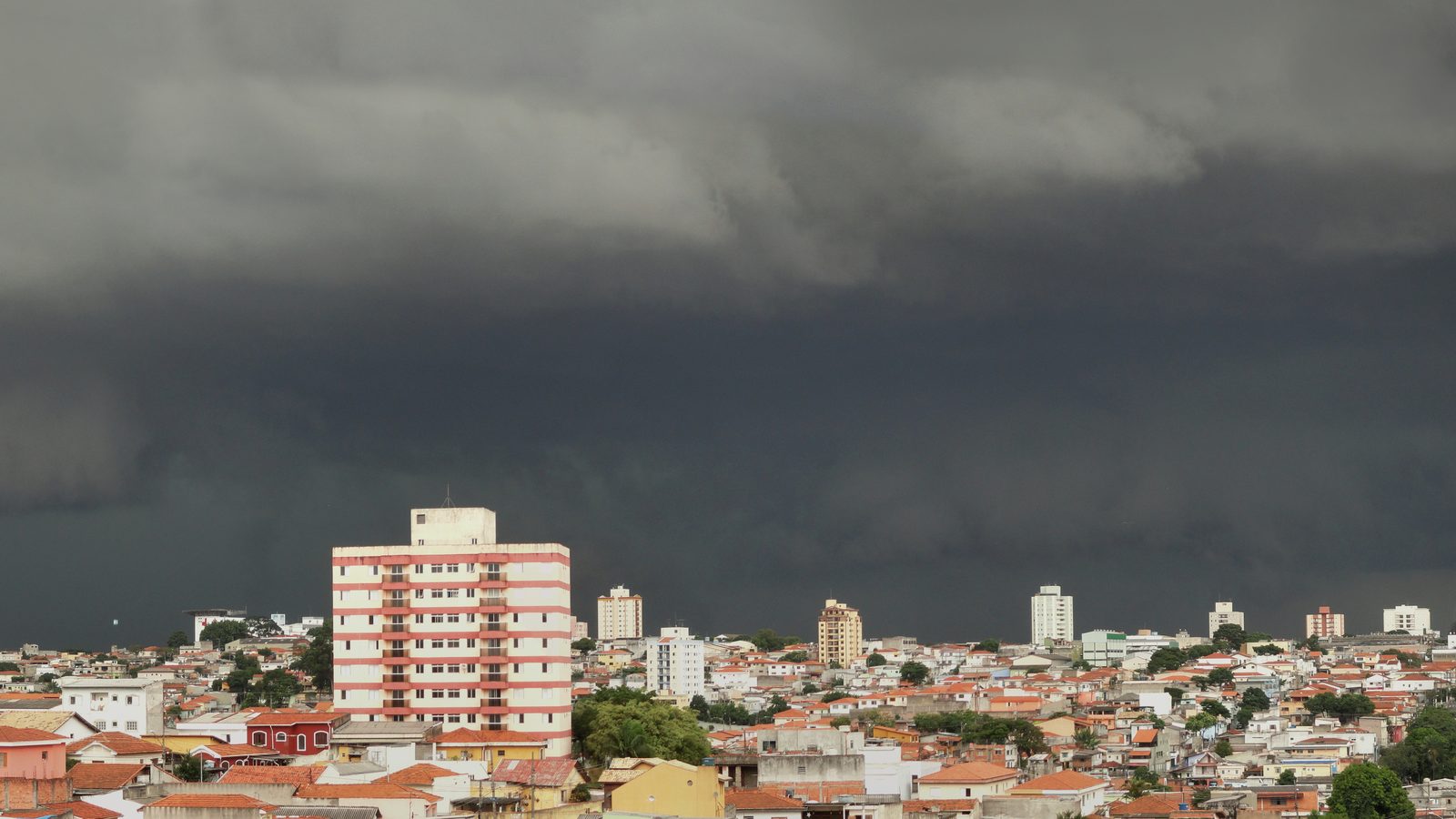 Panorama de uma tempestade de verão sobre São Paulo, com nuvem escura e baixa cobrindo o céu da cidade, tema da previsão de tempestade da USP